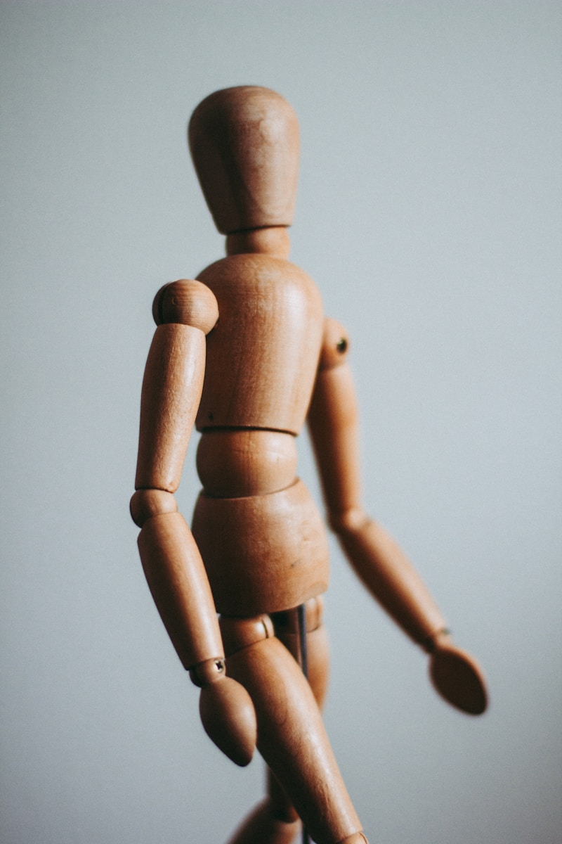 close-up photo of brown wooden doll