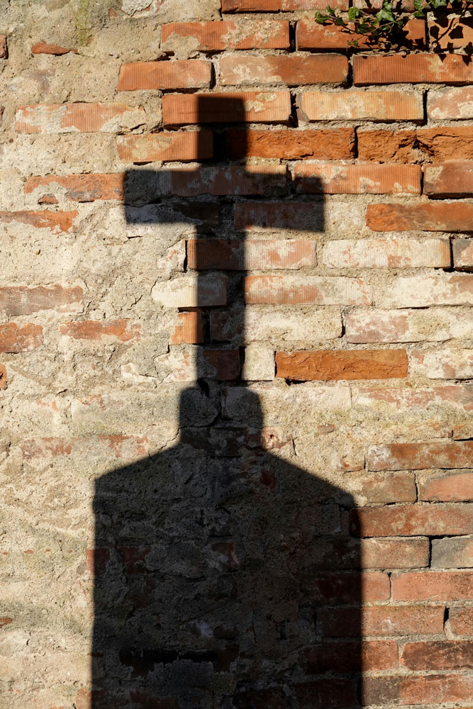 shadow of cross on brick wall