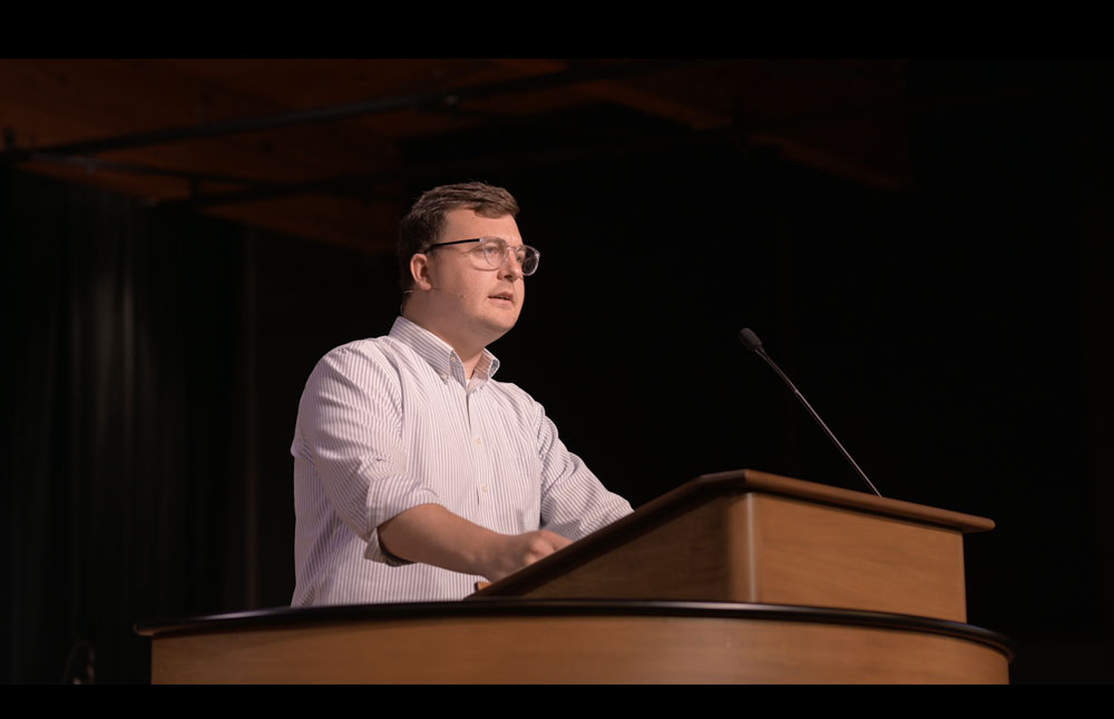 Andrew Gordon standing at chapel podium