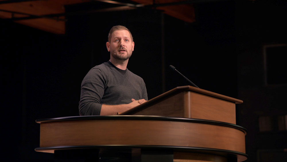 Kyle Knecht standing at chapel podium