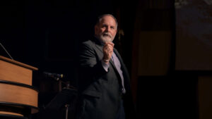 Dr. Williams standing next to chapel podium