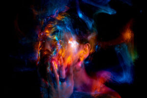 abstract image of multicolor swirls of light covering a female face and hand