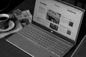 black and white image of a laptop with a news website on the screen