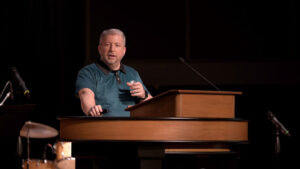 John Stange standing behind chapel podium