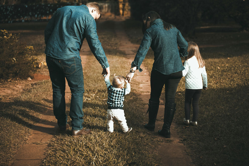 young family walking on a dirt road