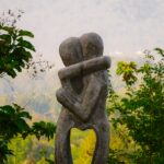 concrete statue of two figures hugging