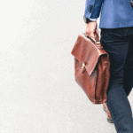 cropped photo of a man walking and holding a briefcase