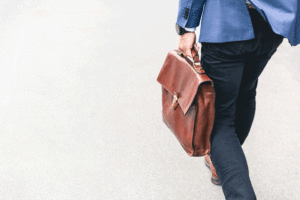 cropped photo of a man walking and holding a briefcase