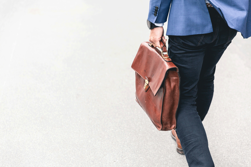 cropped photo of a man walking and holding a briefcase