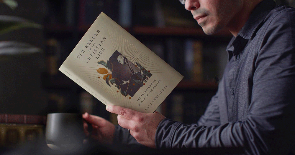 photo of man holding open a copy of Tim Keller on the Christian Life