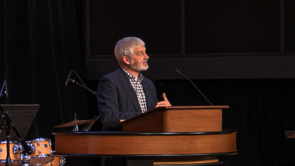 Pastor Tim Bouffard standing behind chapel podium