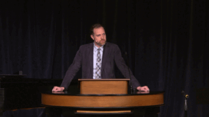 Dr. Adam Porcella standing behind chapel podium