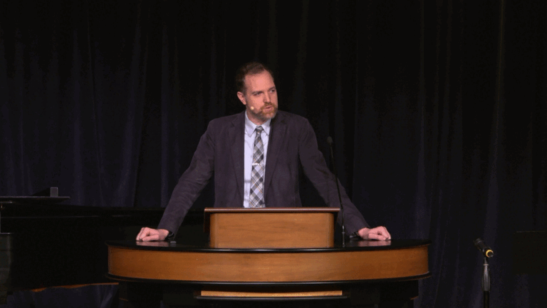 Dr. Adam Porcella standing behind chapel podium