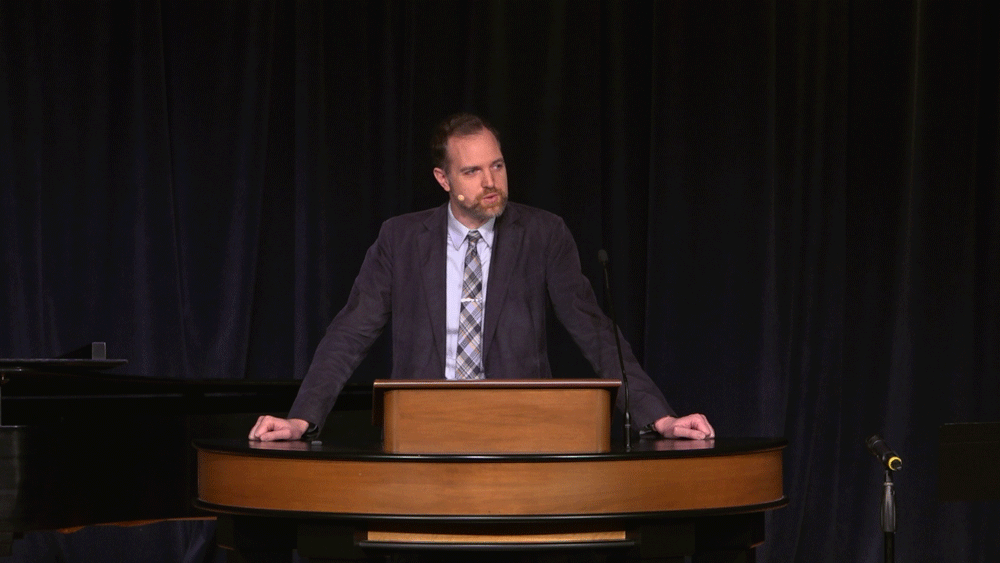 Dr. Adam Porcella standing behind chapel podium