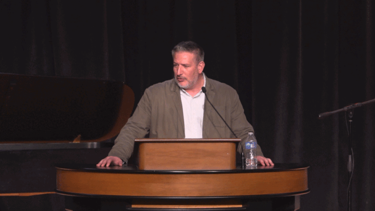 Jared Wilson standing behind chapel podium