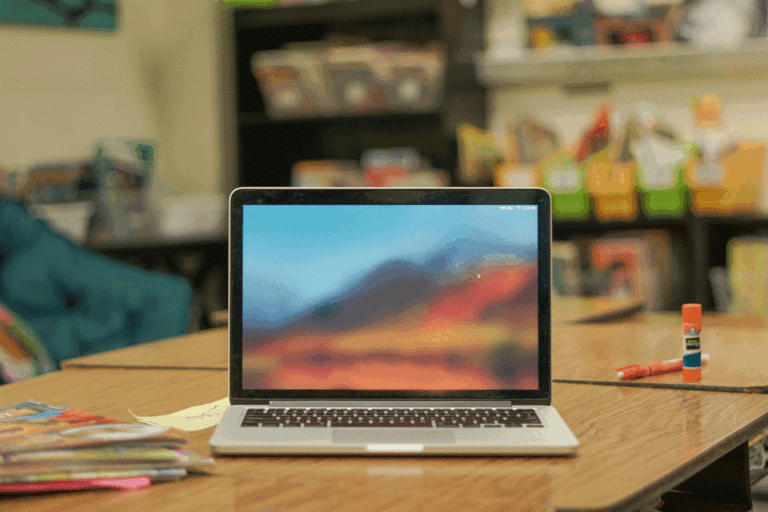 laptop open on desk in an elementary classroom