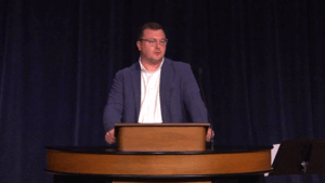 Andrew Gordon standing behind chapel podium
