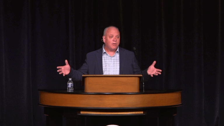 Don Lough standing behind chapel podium