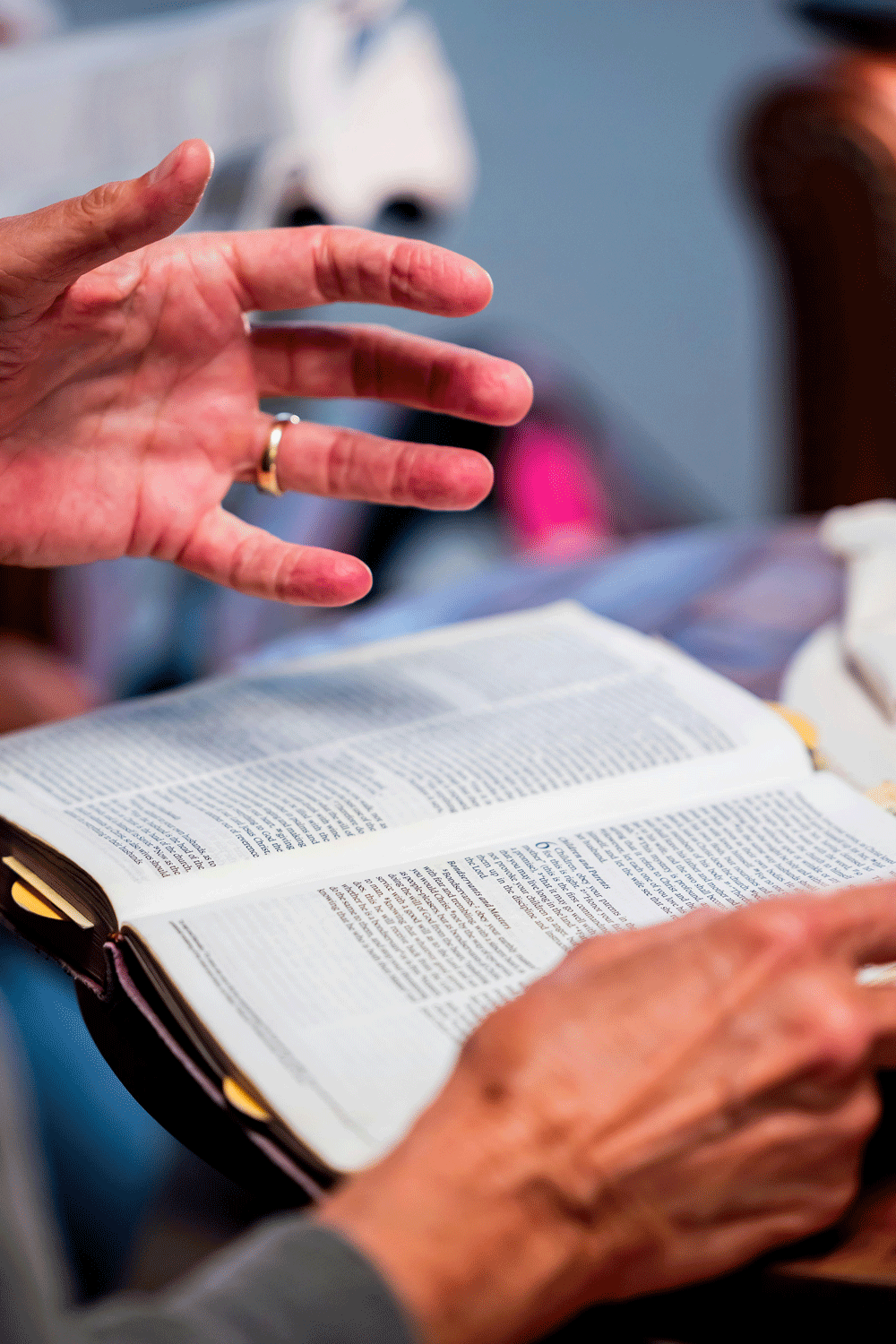 image of a man's hands over an open Bible