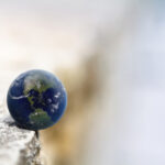image of a small globe balancing on the edge of a concrete ledge