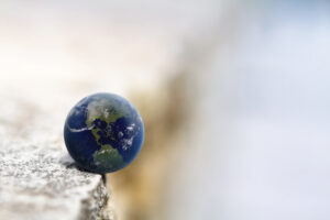image of a small globe balancing on the edge of a concrete ledge