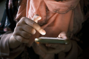 up-close photo of a woman holding a phone in one hand and using her opposite hand to scroll