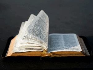 image of open Bible on a table with fanning pages