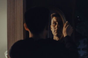 image of man looking at reflection in mirror