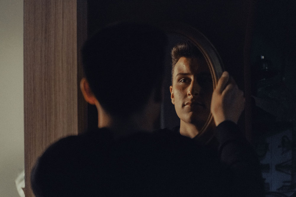 image of man looking at reflection in mirror