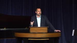 Bryan Murawski standing behind chapel podium