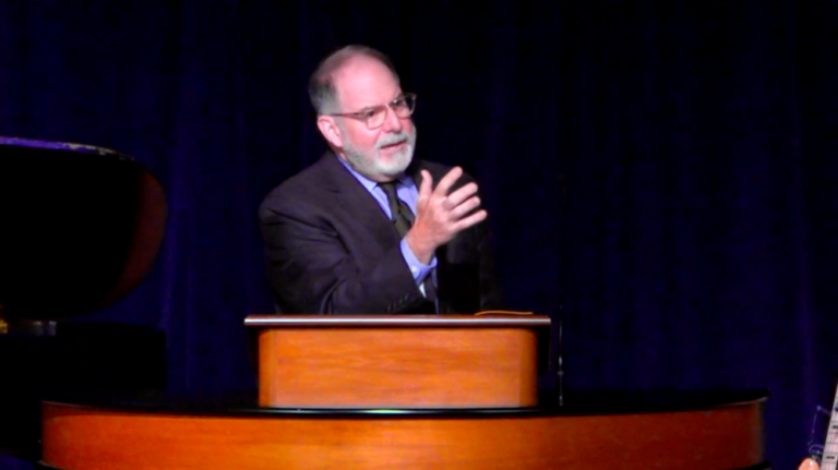 Dr. Williams standing behind chapel podium